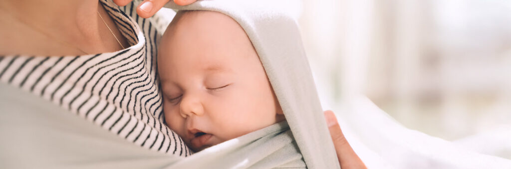 Prawidłowe pozycje do noszenia noworodka i bezpieczne kangurowanie wspomagające rozwój.